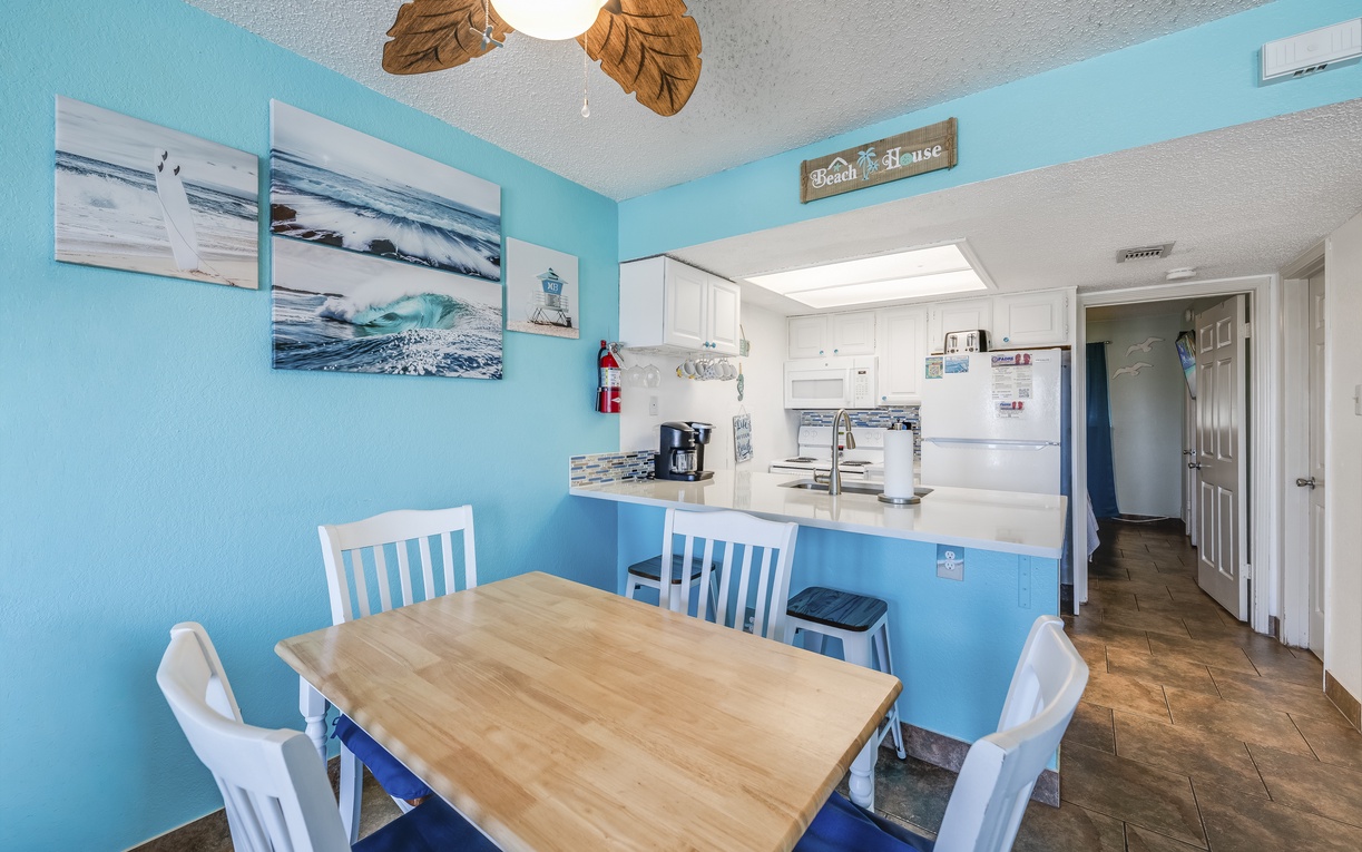 Gather around your beach-themed dining table, where ocean-inspired décor and a fully equipped kitchen await your morning coffee ritual and meal preparations.