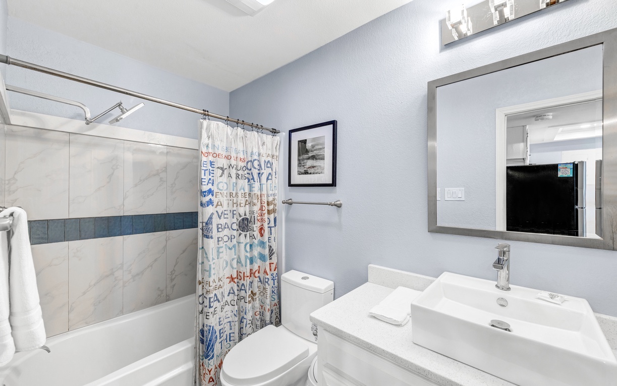 Refresh in your stylish bathroom with modern marble finishes, a spacious tub, and thoughtful amenities for your comfort.
