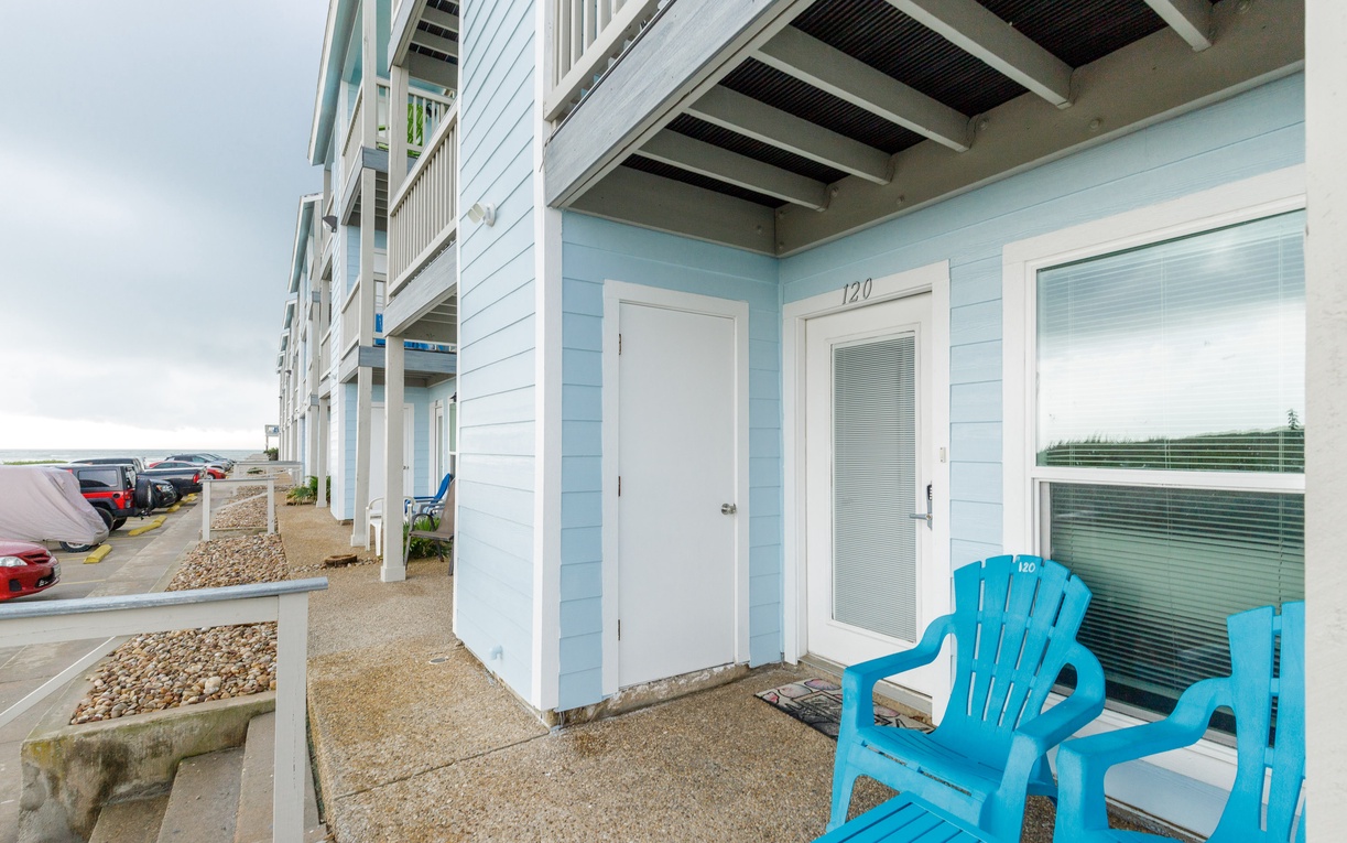 Oceanside retreat with your own private patio featuring vibrant blue chairs—perfect for morning coffee while watching waves.
