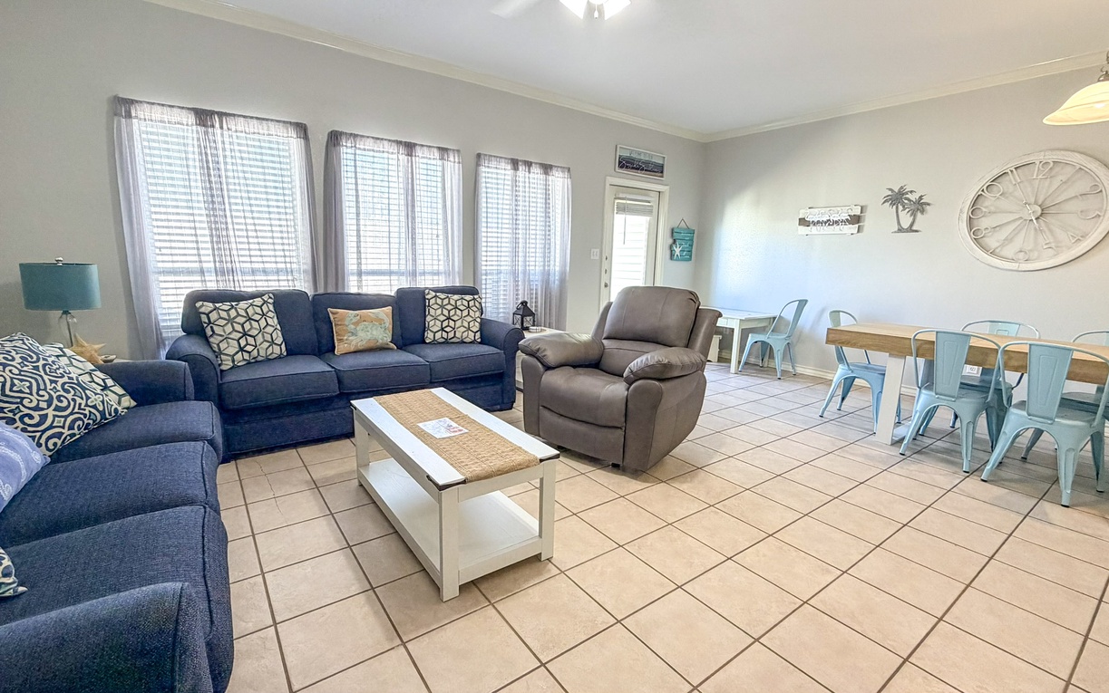 Relax in your spacious living room with plush navy sofas and coastal charm, perfect for gathering with loved ones.