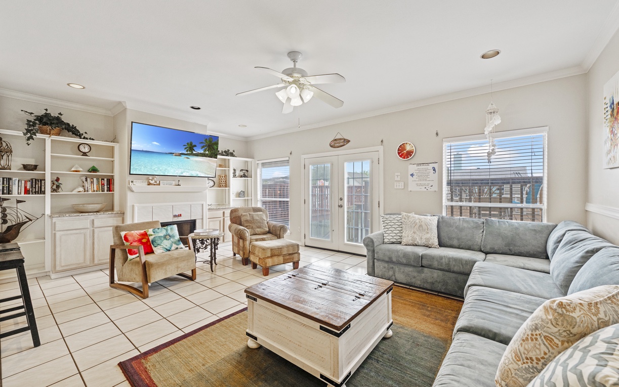 Unwind in your spacious living room with plush sectional seating, entertainment center, and French doors opening to your private outdoor space.