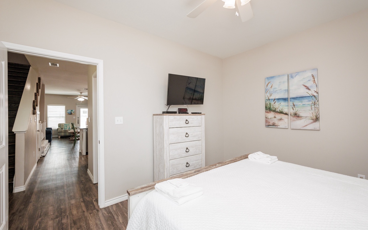 Drift off to sleep in your cozy bedroom, complete with coastal artwork and modern amenities for ultimate relaxation.