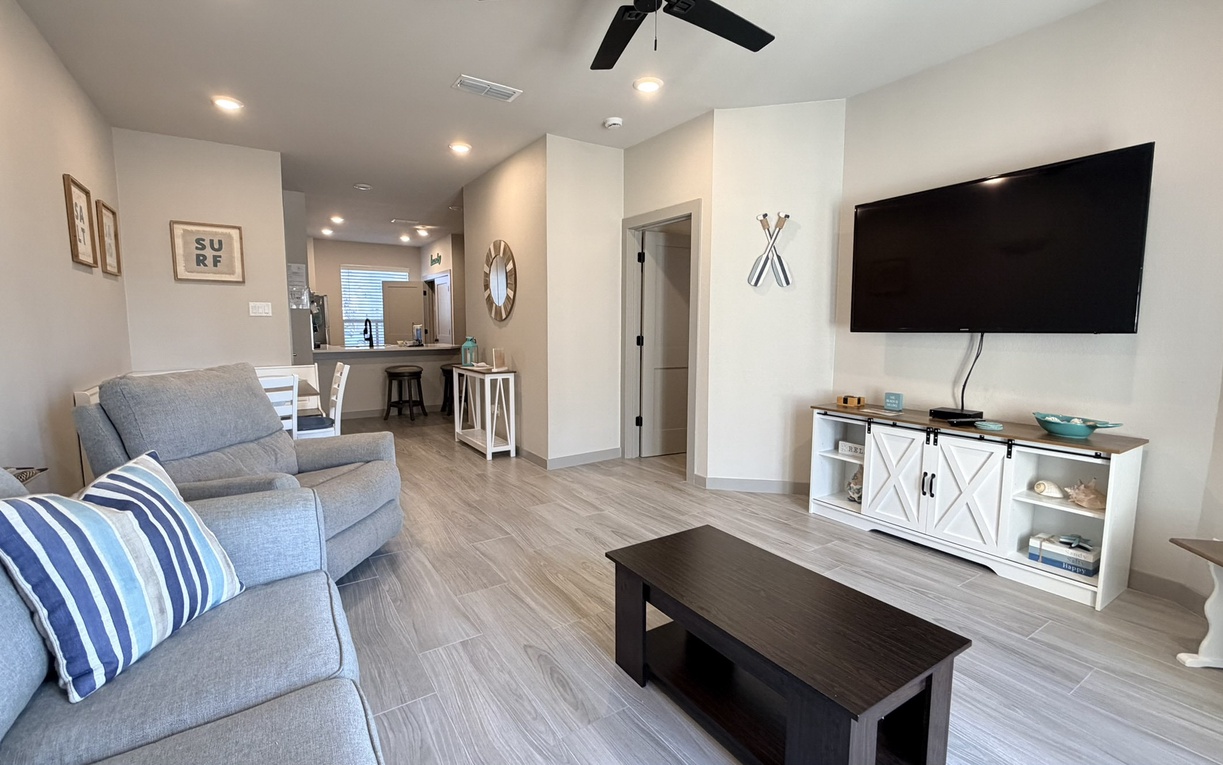 Your comfortable living space features coastal charm with blue accent pillows, perfect for relaxing after beach days.