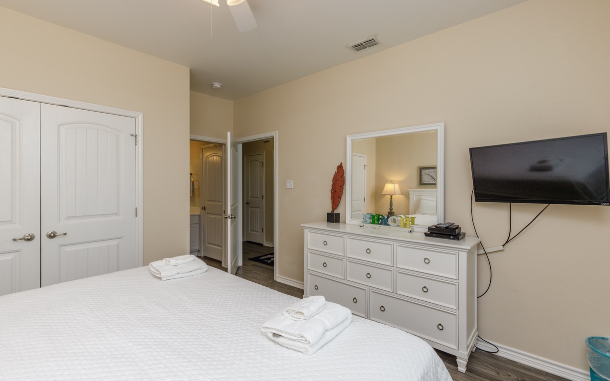 Unwind in your serene bedroom featuring plush linens, spacious storage, and entertainment center for perfect relaxation after exploring.