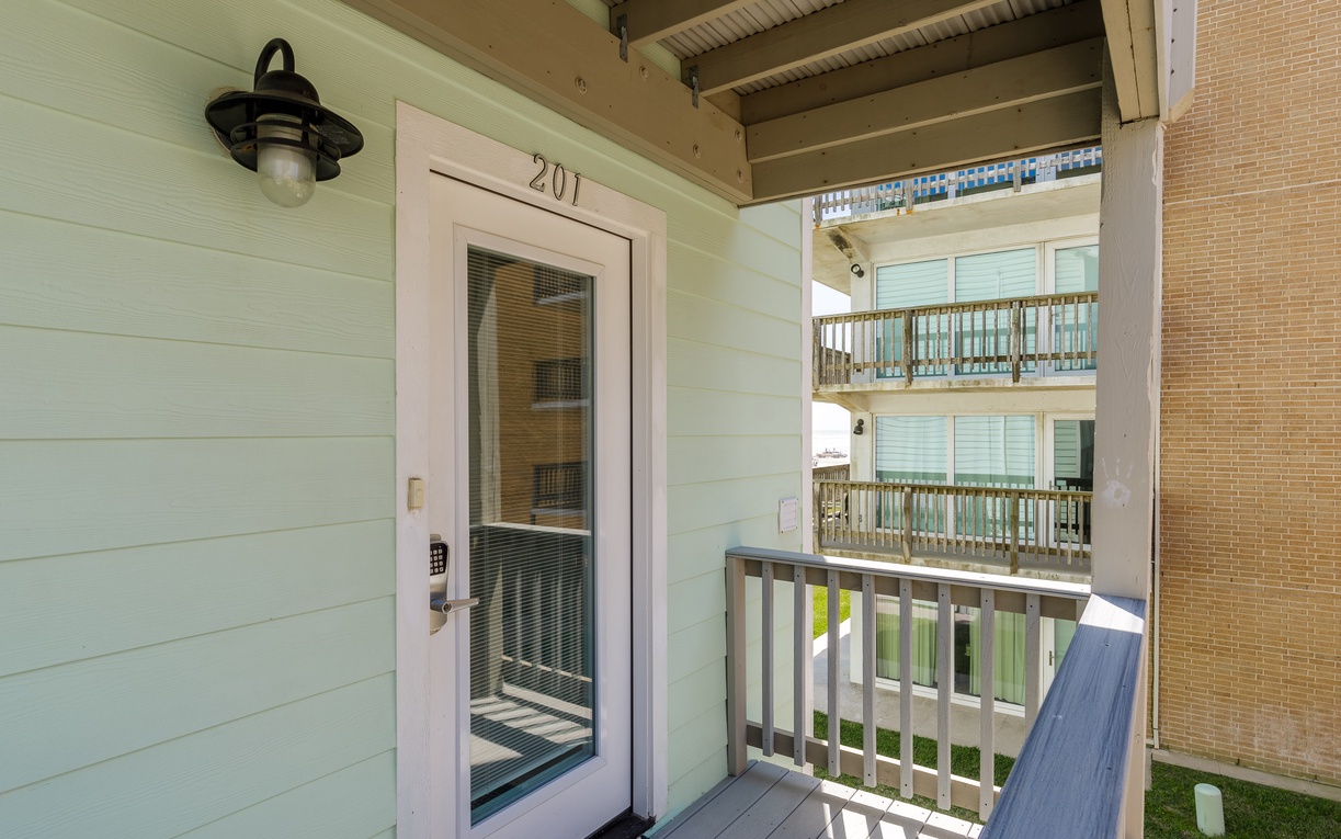 Your private entrance welcomes you to unit 201, where coastal charm meets modern comfort on this peaceful covered balcony.