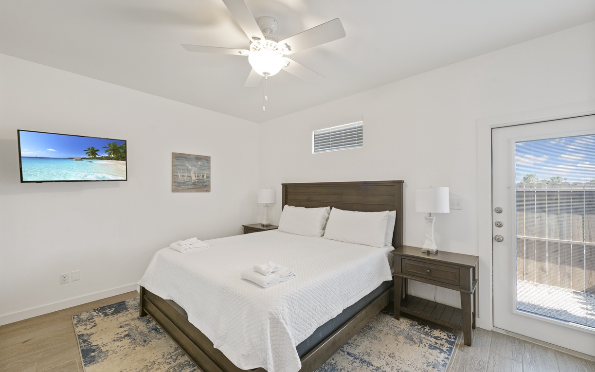 Your peaceful retreat awaits with a plush king bed, tropical views on the mounted TV, and private patio access for morning coffee.