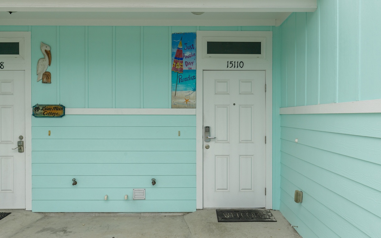 The charming turquoise exterior and welcoming entrance of your beachside cottage retreat.