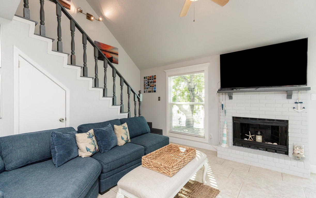 Relax in your bright living room with plush seating, cozy fireplace, and entertainment center perfect for unwinding after beach days.