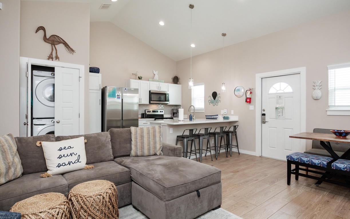 Relax in your bright, modern living space with a plush sectional sofa, fully equipped kitchen, and coastal touches that make you feel right at home.
