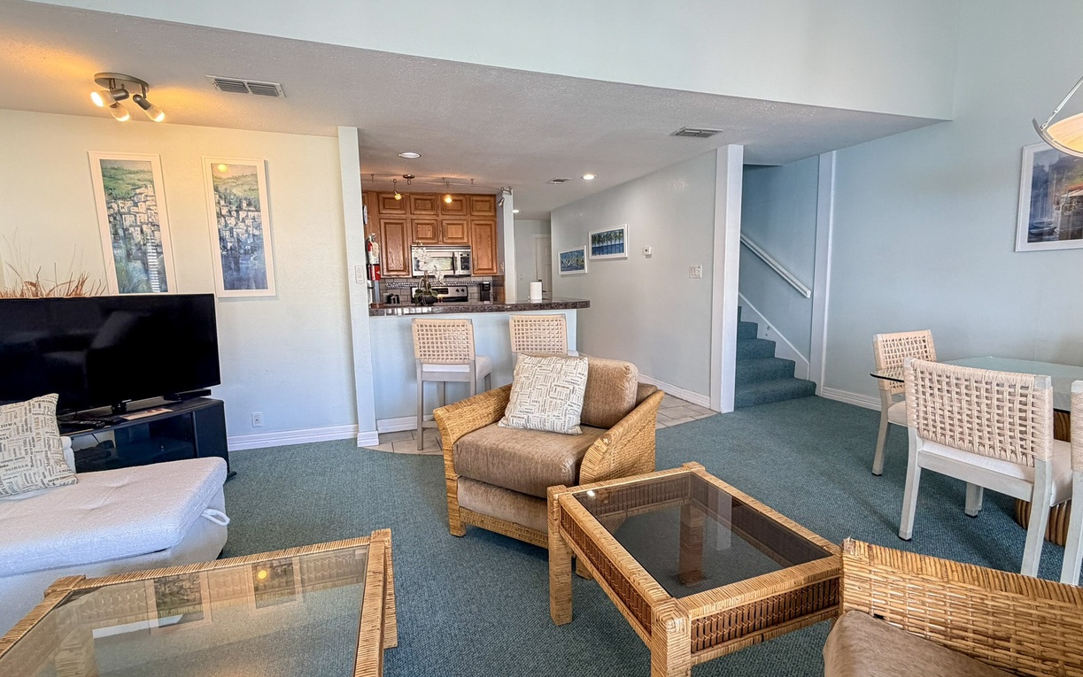 Unwind in your spacious retreat with coastal vibes—wicker furnishings, open kitchen, and dining area create the perfect space for relaxation.