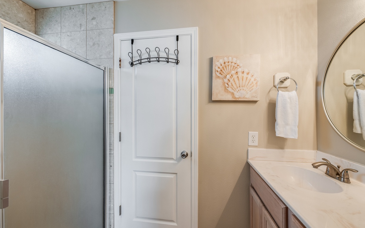 Step into your private bathroom oasis with warm coastal touches, where seashell art and soft towels await your arrival.