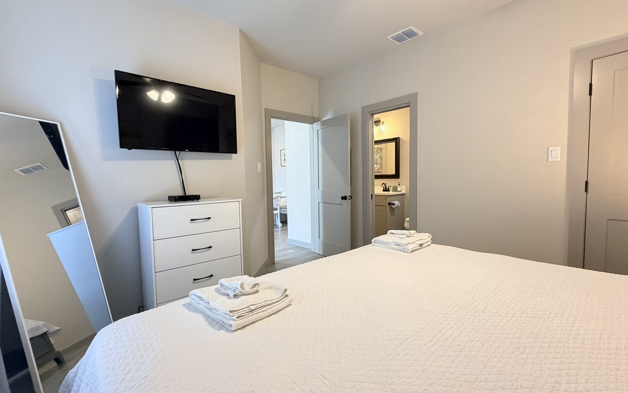 Sink into crisp white linens after a day exploring, with your own wall-mounted TV for cozy evenings in this serene retreat.