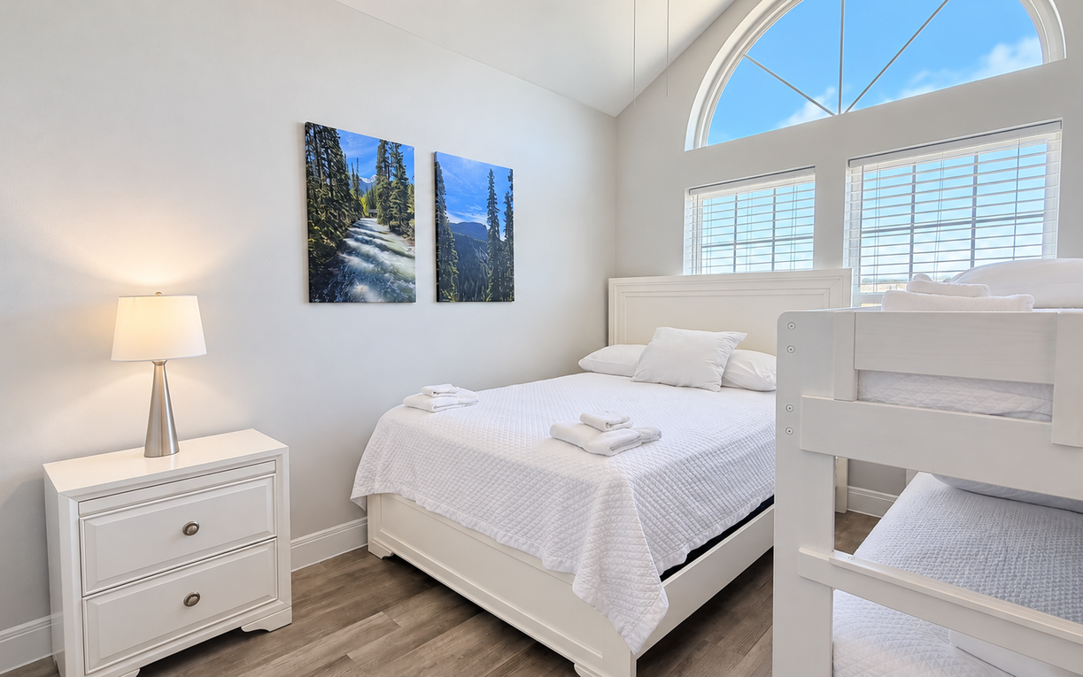 Relax in this bright bedroom, where a comfortable queen bed, twin-over-twin bunk beds, and coastal touches create a welcoming retreat
