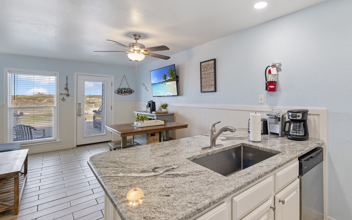 Your granite-topped kitchen island becomes the heart of your stay, with coffee brewing station ready for mornings overlooking coastal views.