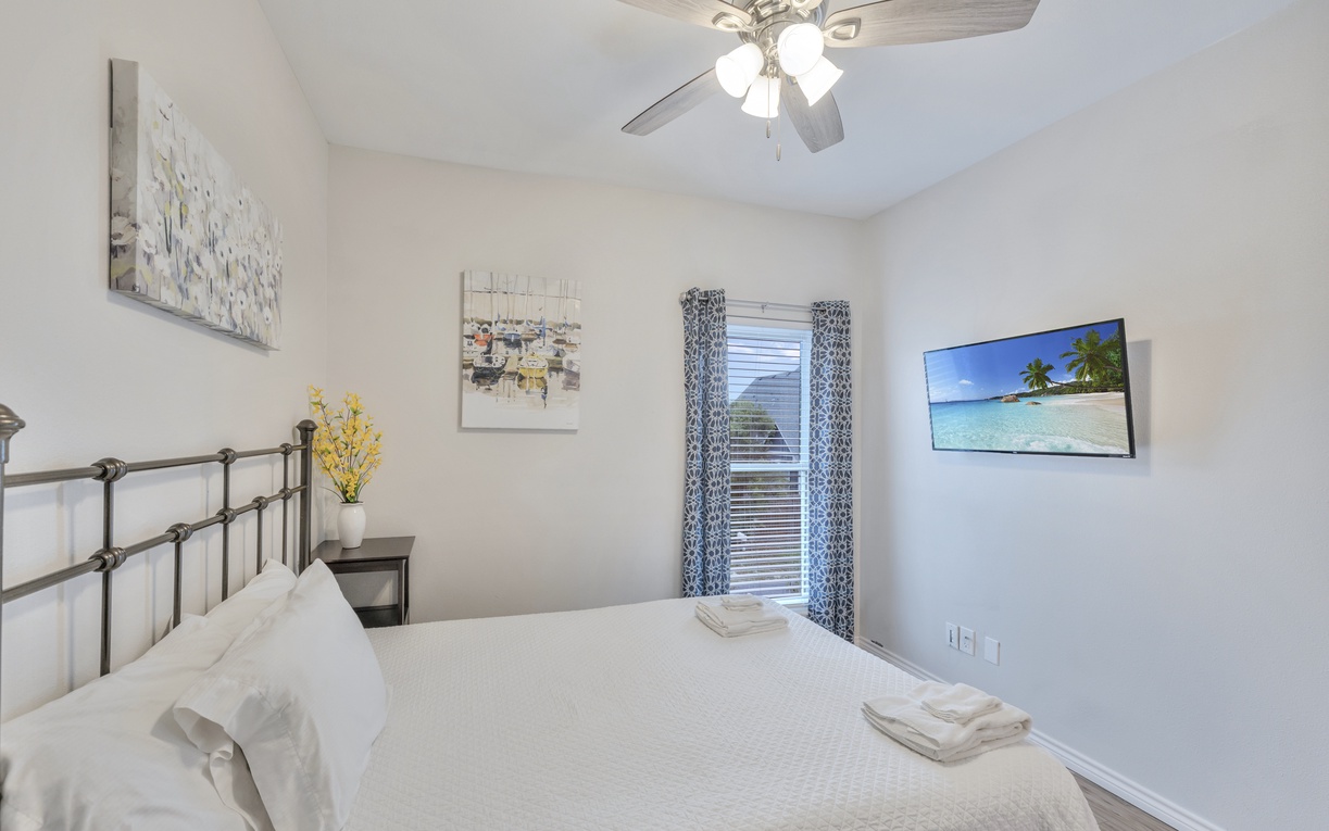 Unwind in your bright bedroom with plush bedding, wall-mounted TV, and gentle ceiling fan keeping you comfortable all night.