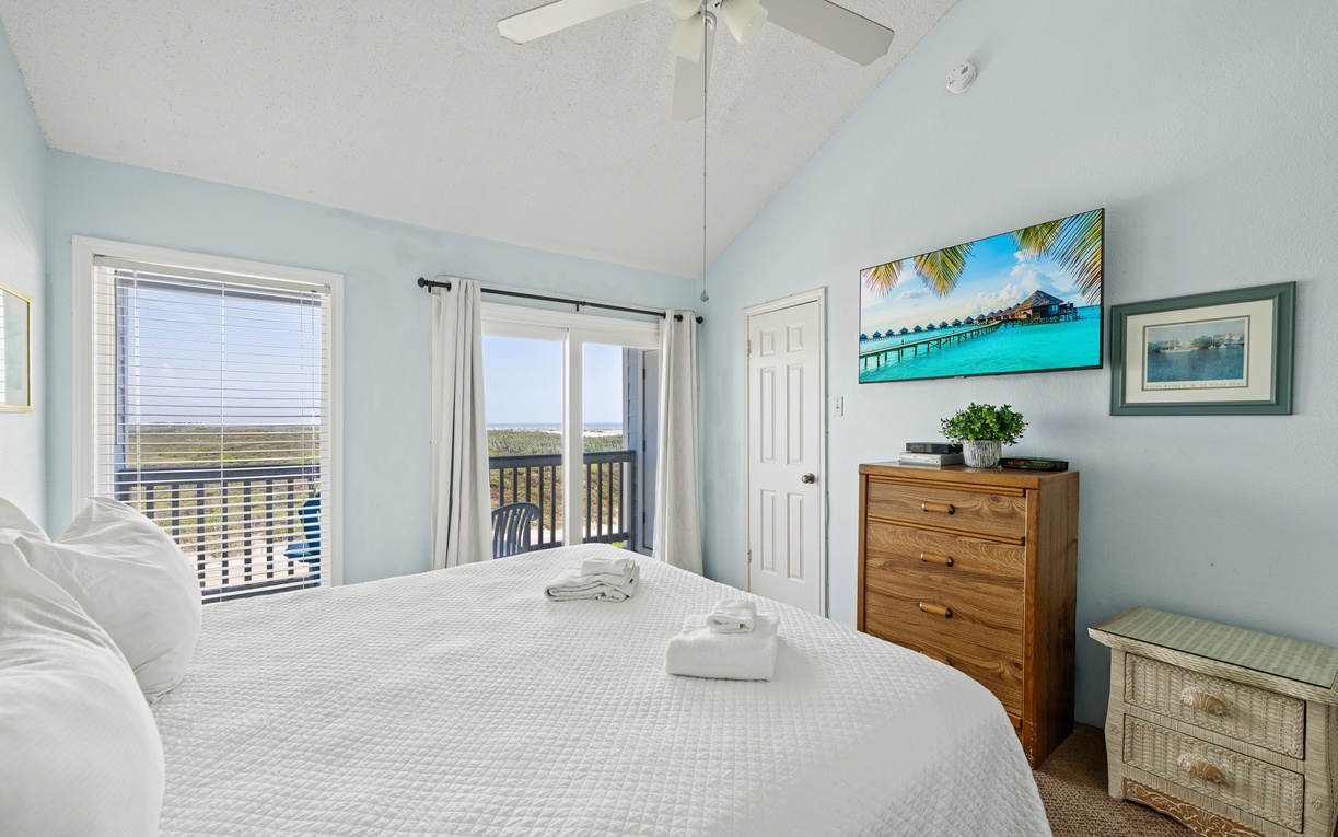 Sink into crisp linens and let the ceiling fan's gentle breeze lull you to sleep while marshland views stretch beyond your balcony door.