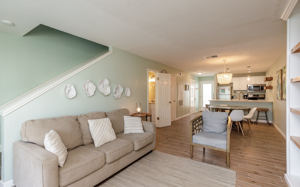 Sink into the plush sofa and feel instantly at home in this bright, coastal-inspired living space with your open kitchen nearby.