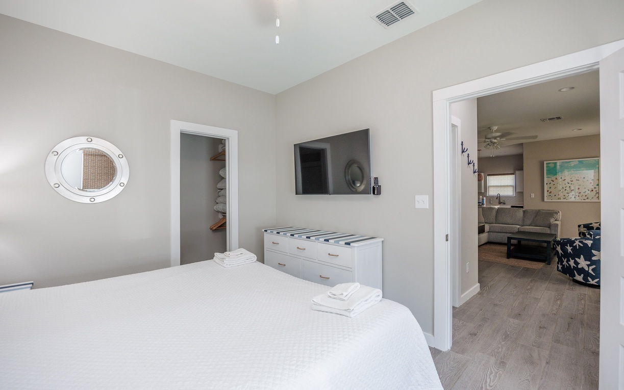 Your serene bedroom features crisp white linens and nautical touches, with an ensuite and living area nearby for perfect relaxation.