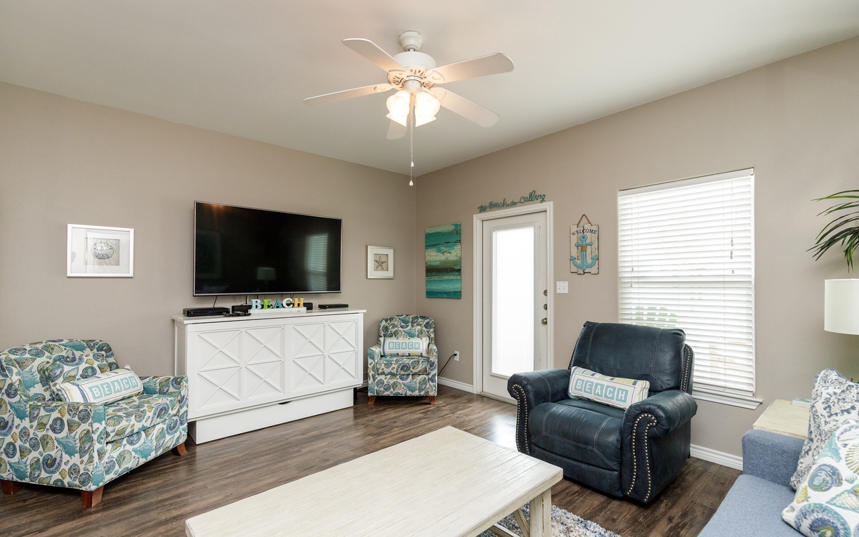 Relax in your comfortable living room with coastal decor, flat-screen TV, and plenty of seating for your group.