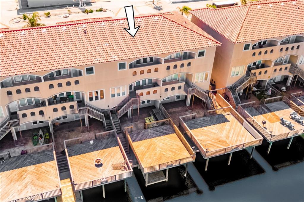 Spacious waterfront property with Mediterranean-style architecture featuring red tile roofs and private dock access along peaceful canal waters.