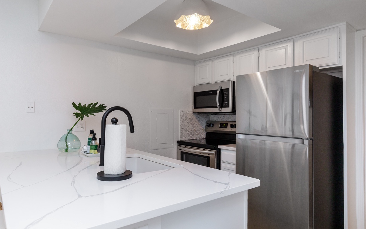 Your modern kitchen features sleek white cabinets, marble countertops, and stainless steel appliances for effortless meal preparation.
