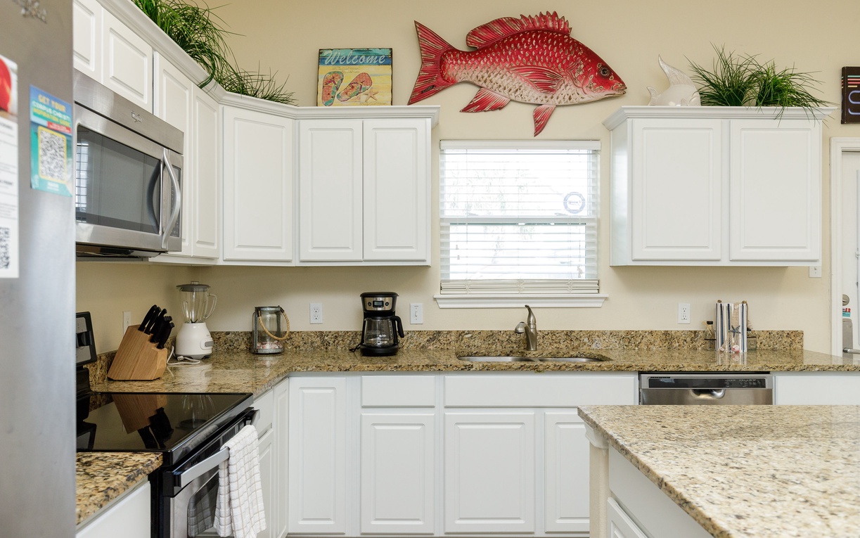 Your fully equipped kitchen awaits with granite counters, modern appliances, and coastal charm—perfect for preparing meals during your beach getaway.