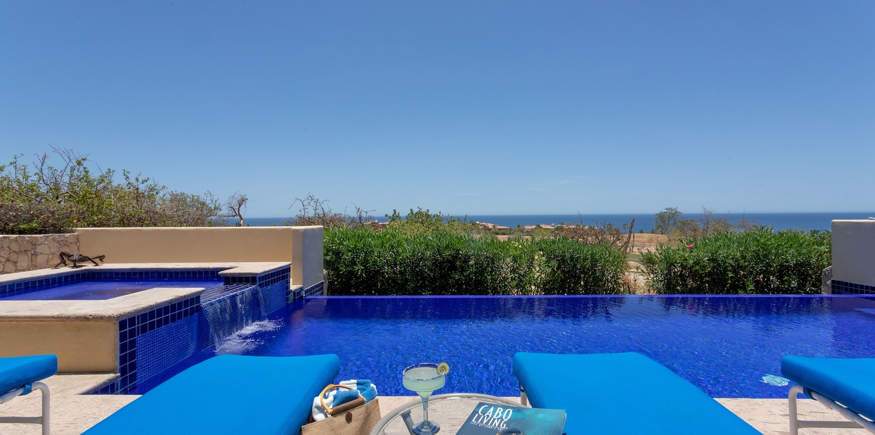 Lounge by the pool on a sunny day with an incredible view