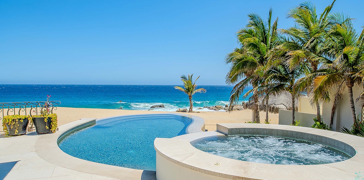 Soak in your private hot tub steps from the pool, with swaying palms, golden sand, and endless turquoise ocean stretching before you—pure beachfront bliss.