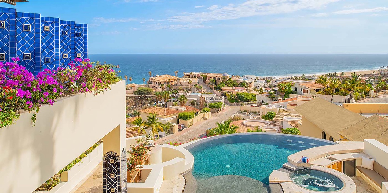 A stunning coastal oasis awaits you—this private pool and hot tub sit framed by lush bougainvillea and sweeping ocean views, offering the perfect setting for your sun-soaked escape.