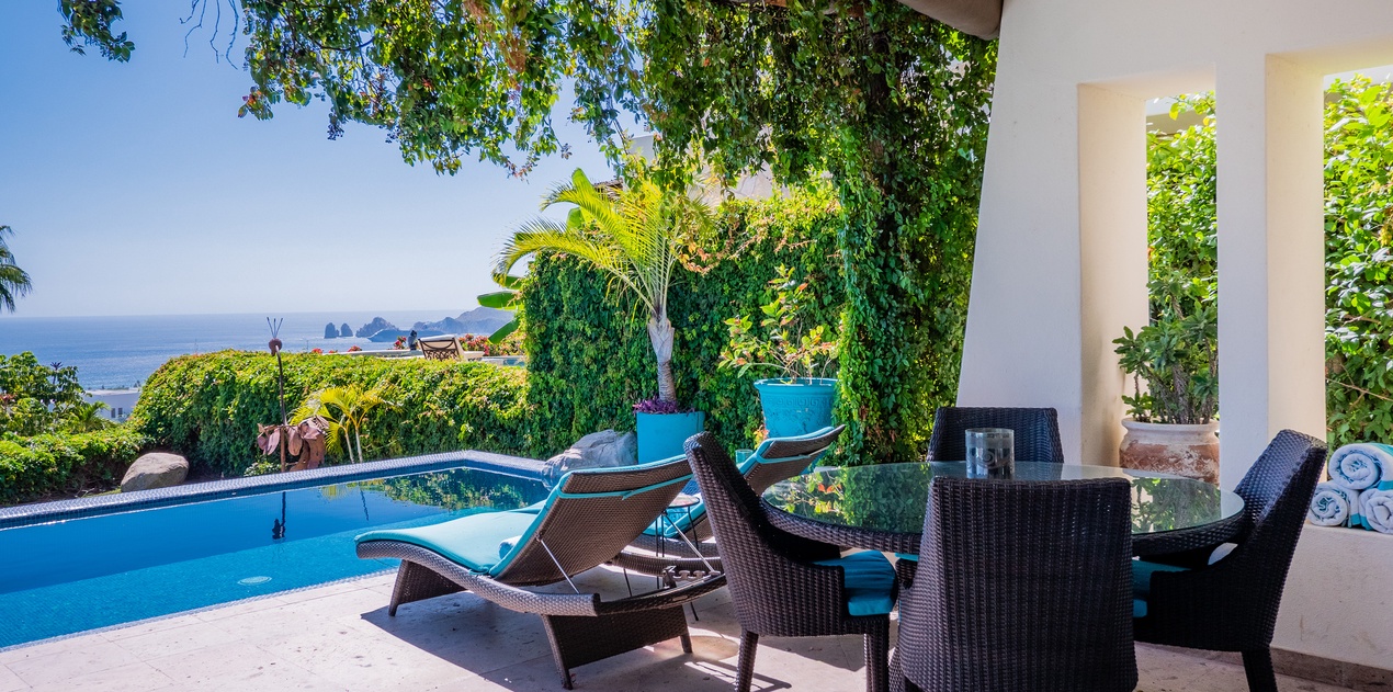 Poolside patio with shady seating area and ocean views