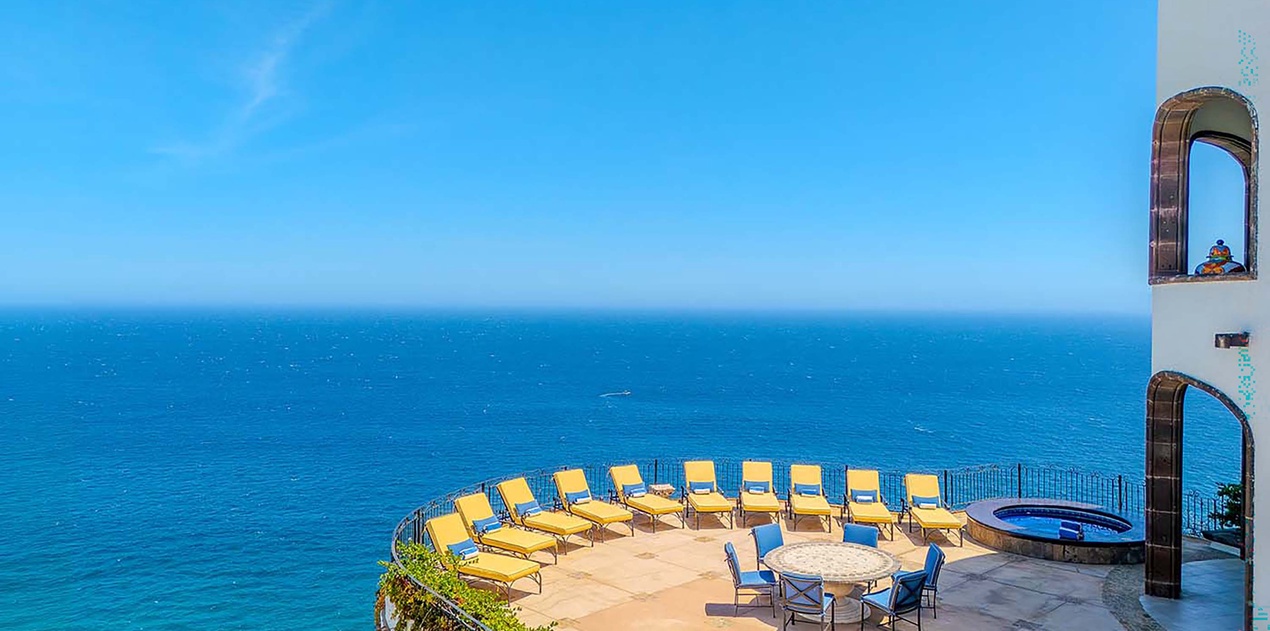 Imagine lounging on your private sun terrace with endless blue ocean views. This Mediterranean-style patio offers comfortable seating, a dining table for al fresco meals, and the soothing sound of waves below.