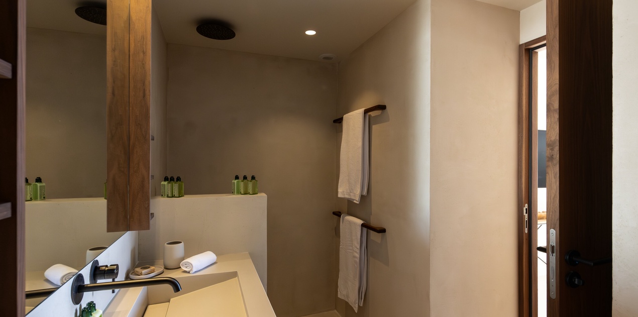 Your modern bathroom features warm wood accents, premium amenities, and a sleek walk-in shower for ultimate comfort.