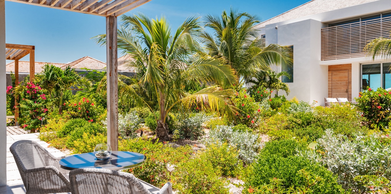 Sip your morning coffee while gazing at lush tropical gardens framed by swaying palms and vibrant blooms from your private terrace.
