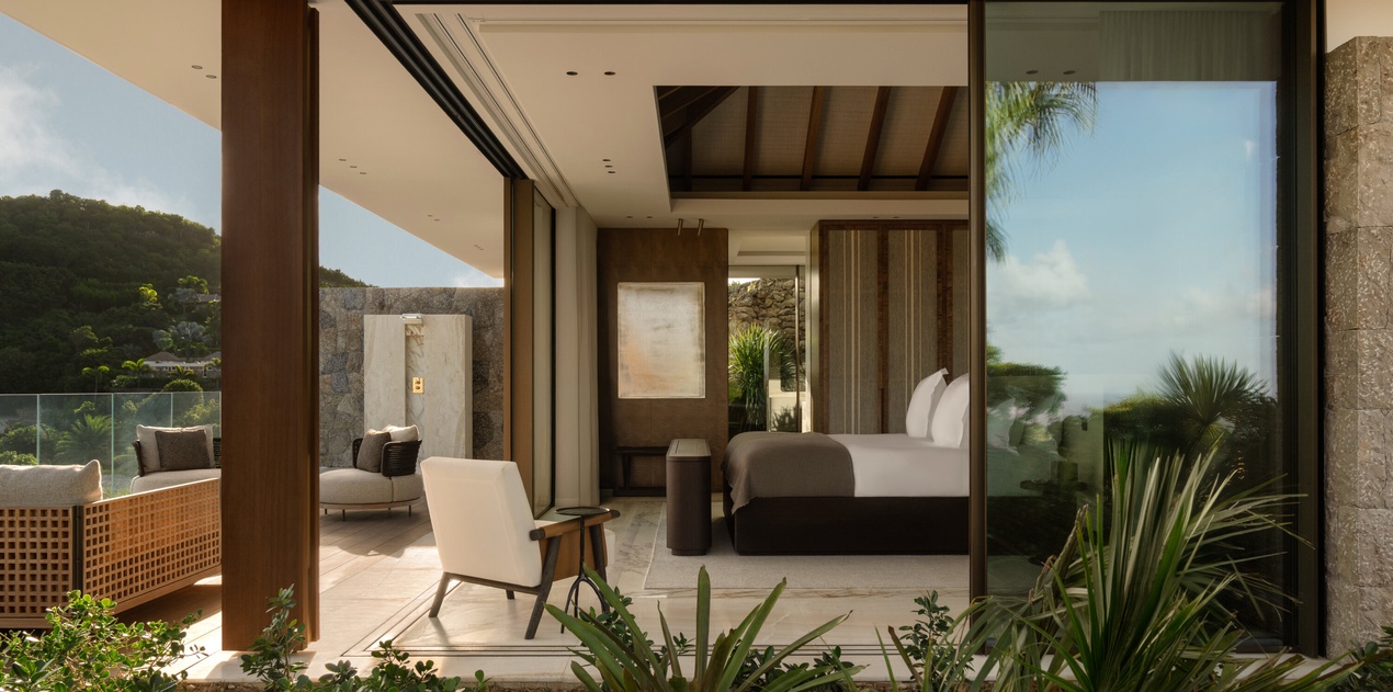 Your sophisticated bedroom flows seamlessly onto a private terrace, where tropical gardens frame stunning mountain views beyond.