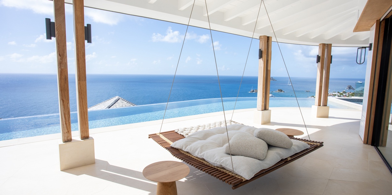Drift away on your private hanging daybed while gazing at endless ocean views through floor-to-ceiling windows.