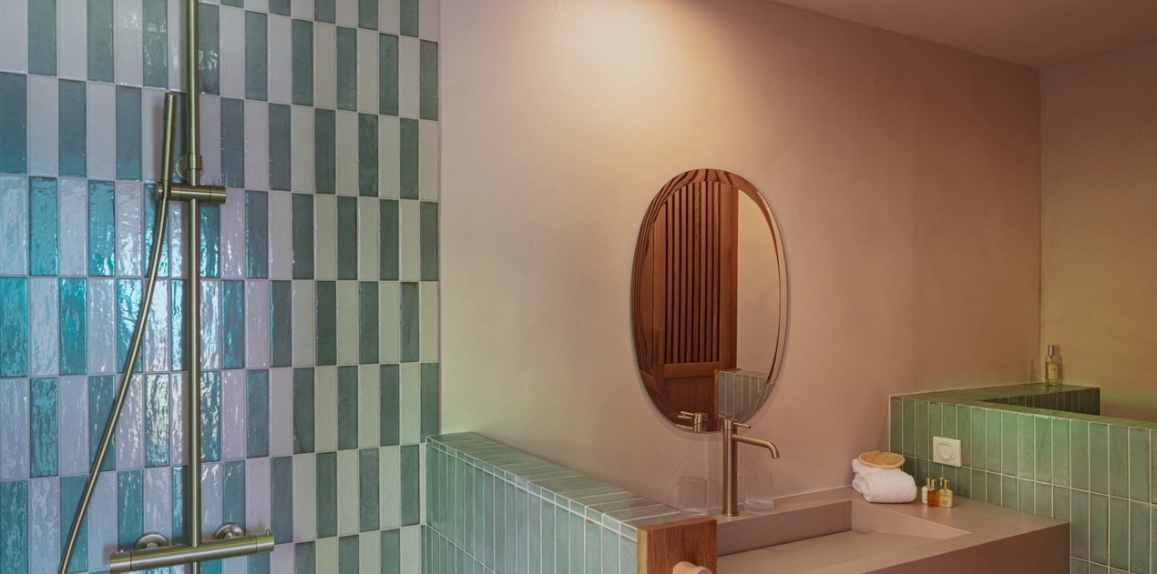 Step into your modern sanctuary featuring glossy seafoam tiles, sleek fixtures, and a warm glow that turns every refresh into a moment of pure relaxation.