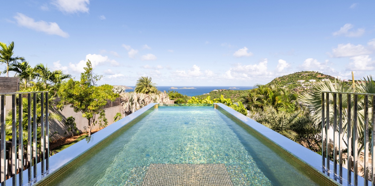 Dive into your private infinity pool as tropical breezes carry ocean scents and panoramic views stretch endlessly before you.