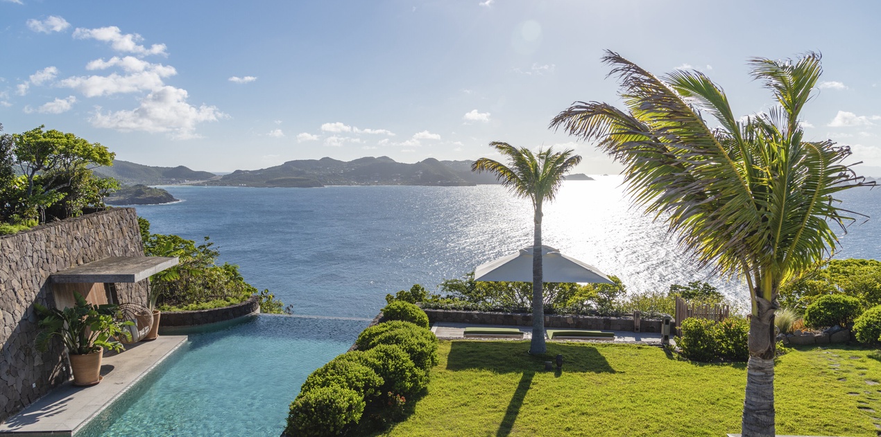Stunning oceanfront property with infinity pool overlooking pristine waters and tropical islands beyond.