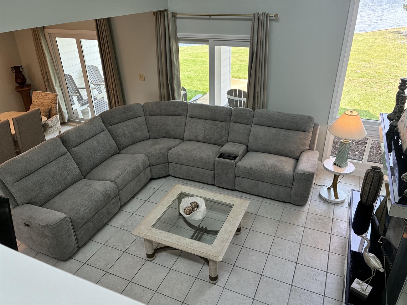 Sink into your spacious sectional sofa with stunning waterfront views through glass doors leading to your private outdoor seating area.