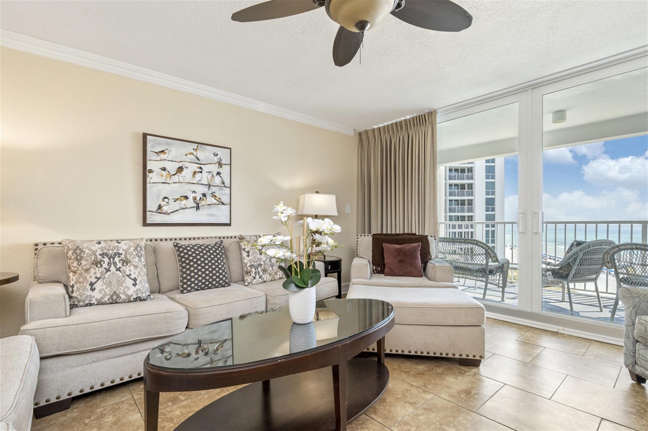 Relax in your sophisticated coastal living room with plush seating and stunning ocean views through floor-to-ceiling windows.