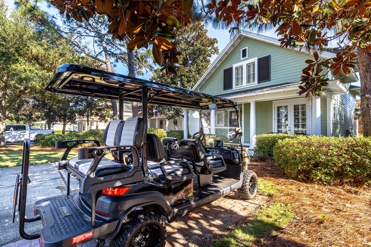 Charming mint green property with convenient golf cart access for easy exploration of the surrounding tree-lined neighborhood.