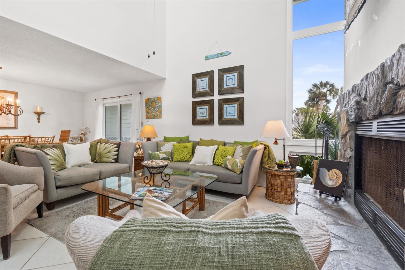 Unwind in your elegant living room with comfortable seating, warm fireplace, and stunning mountain views through floor-to-ceiling windows.