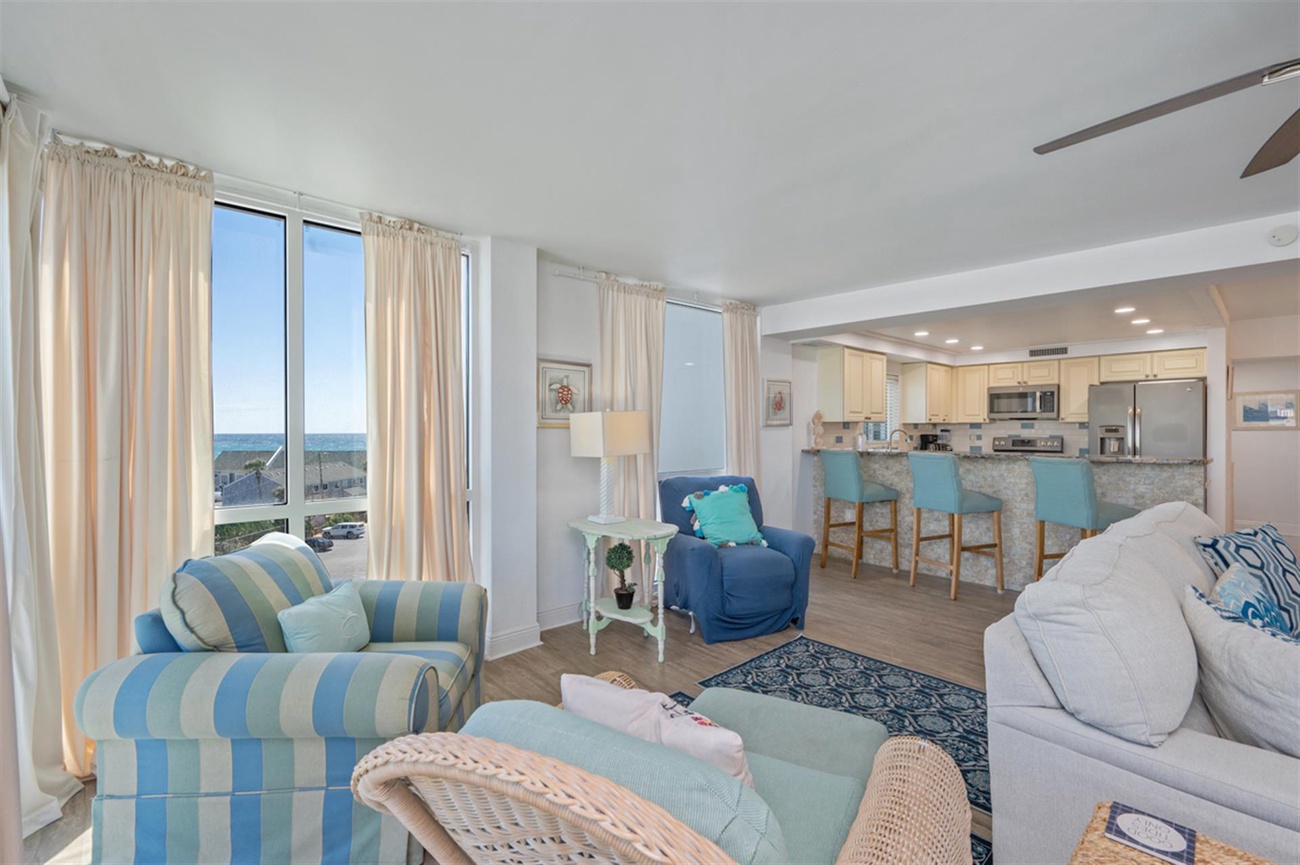 Sink into soft coastal furniture while ocean views fill your windows in this bright, airy living space.