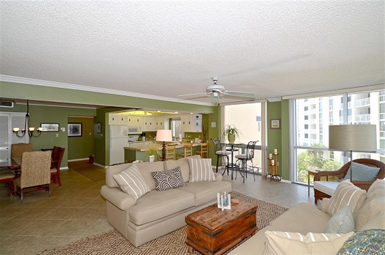 Relax in your spacious open-plan living area with comfortable seating, modern kitchen, and stunning city views from your private balcony.
