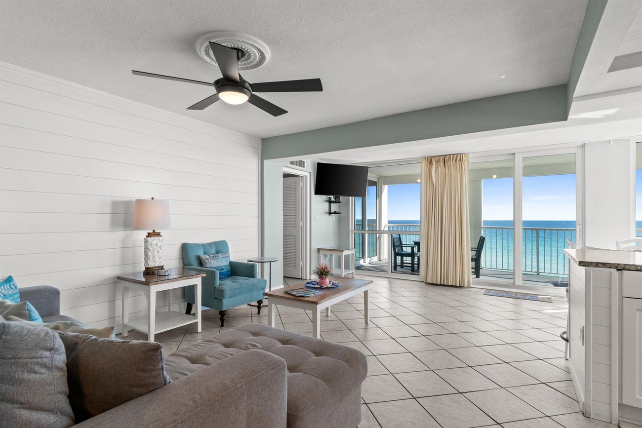 Relax in your bright oceanfront living room where coastal comfort meets stunning sea views through floor-to-ceiling windows.