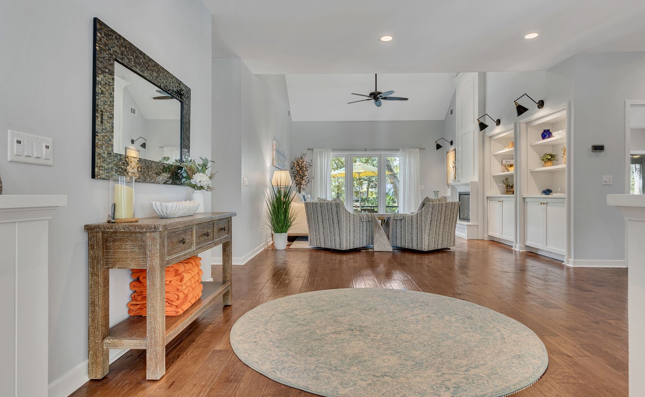 Relax in your elegant open-concept living space with gleaming hardwood floors, built-in shelving, and comfortable seating perfect for unwinding.