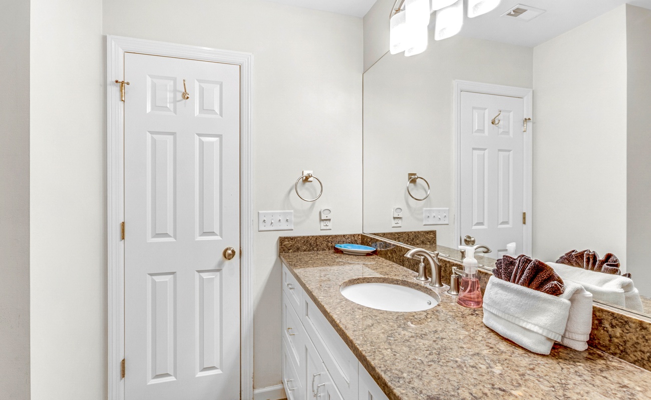 Your spacious bathroom features elegant granite countertops, crisp white cabinetry, and thoughtful touches that make your daily routine feel luxurious.