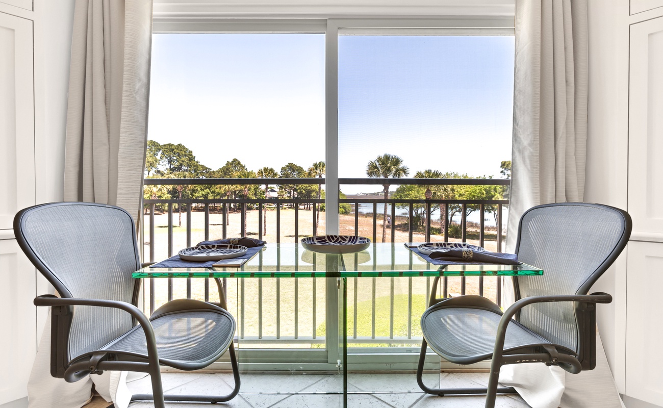 Enjoy intimate meals at your private glass dining table with stunning golf course views through floor-to-ceiling windows.