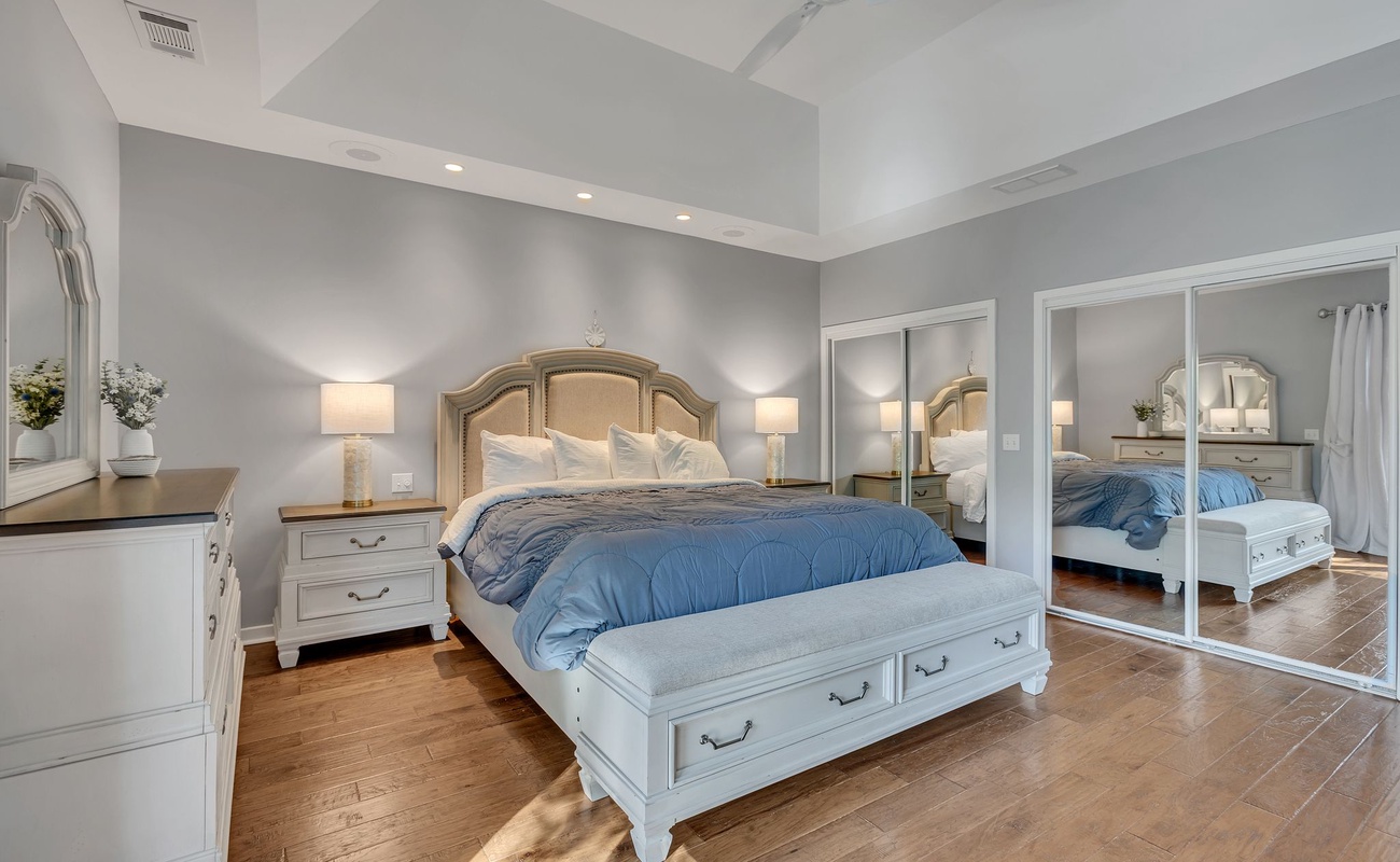 Sink into this serene bedroom where soft gray walls and elegant furnishings create your perfect retreat.