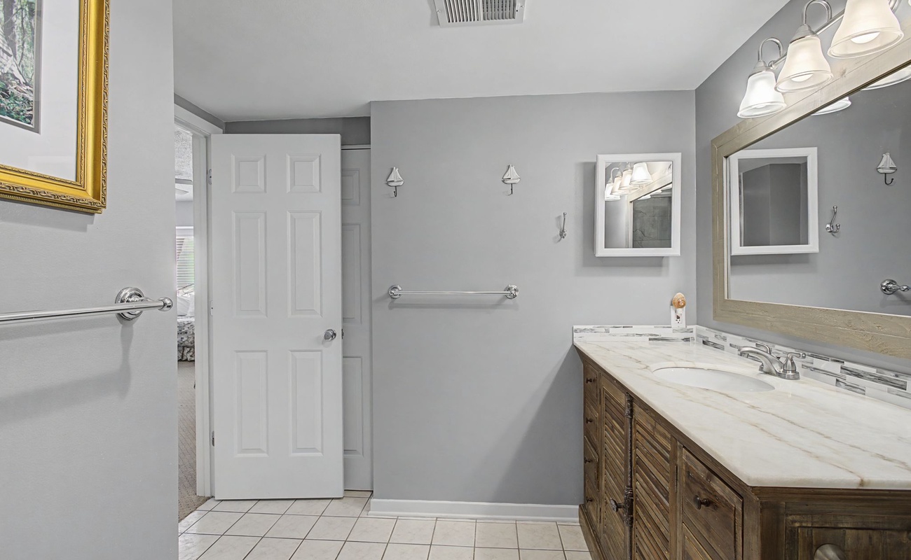 Step into your elegant bathroom featuring marble countertops, warm wood vanity, and thoughtful accessibility touches for your comfort.